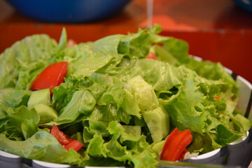 Lettuce leaves in a salad bowl with tomato pieces