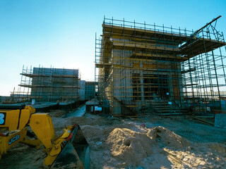 construction site with scaffolding and building materials, blue sky background