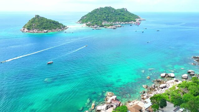 Discover paradise on an island adorned with powdery sands, perfect for snorkeling and soaking up the sun amid vibrant marine wonders. Aerial view. Tropical sea background. Koh Tao, Thailand. 4K.
