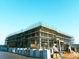 construction site with scaffolding and building materials, blue sky background