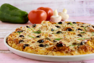 Tuna Fish Pizza topping with capsicum, mushroom, tomato and olives served in dish isolated on table side view of arabic fastfood