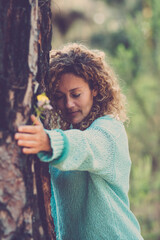 Nature love and environment. Sustainable lifestyle people. One woman bonding a big trunk tree in the forest woods. Concept of natural protection. Green woods background. Stop deforestation outdoors