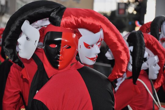Black and red court fool at the carnival. Black and red jester with many masks in international carnival parade in Rijeka city, Croatia