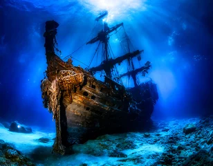 Foto op Canvas Ancient sunken pirate ship resting in the depths of the blue sea. Underwater photo © Arda ALTAY