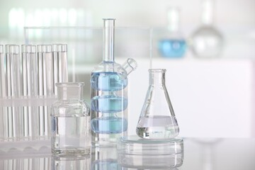 Laboratory analysis. Different glassware with liquid on white table indoors. Space for text