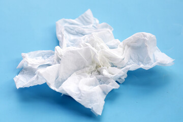 Crumpled tissue paper. Facial tissue on blue background.
