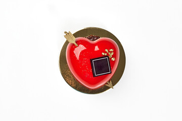 Obraz premium Red heart-shaped strawberry mousse cake with gold arrow
