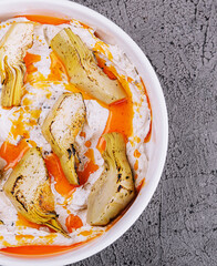artichokes with truffle sauce in white bowl