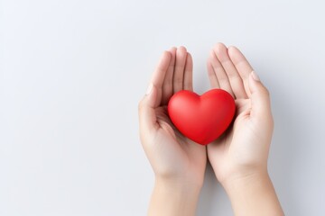 Female hands presenting a red heart symbol, isolated on white. Hands Holding Red Heart with Copy Space