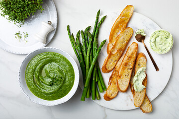 Healthy asparagus, green peas, watercress cream soup with toasted bread and wild garlic, ramson...