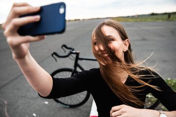 Happy woman taking a selfie with tousled hair in front of the face