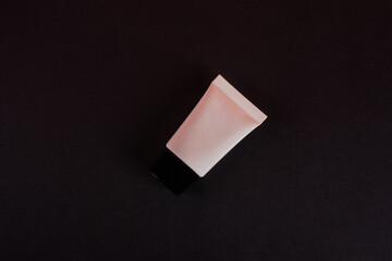 Plastic white tube for cream or lotion. Skin care or sunscreen cosmetic on black background 