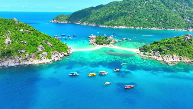 Koh Nangyuan charms with its idyllic scenery, inviting travelers to indulge in sun-soaked bliss amidst azure waters. Flight over the ocean. Ko Nangyuan, Surat Thani Province, Southern Thailand. 4K.
