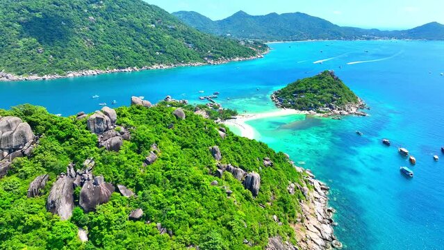 Paradisiacal gem nestled in azure waters, where palm-fringed beaches meet lush jungles, a haven of tranquility and adventure awaits. Aerial view from drone. Nature stock footage. Koh Tao, Thailand.
