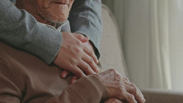 Family concept. A grandfather who receives love and care from his family. Caring for elderly parents Along with the hands that hug Grandfather in his old age.