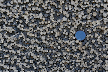 Small round window surrounded by large logs resembling timber logs