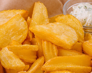 Potato wedges in basket and sauce