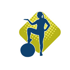 Fototapeta na wymiar Silhouette of a slim sporty woman doing pilates exercise using gym ball. Silhouette of a sporty female doing physical exercise using fitness ball. 