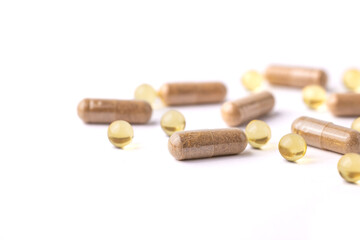 Oblong Brown and Round Yellow Pills Scattered on a White Background