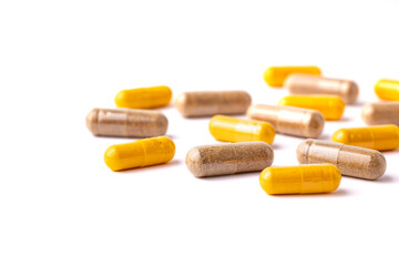 Brown and Orange Capsule Pills Scattered on a White Background