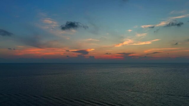 Witness the ethereal blend of sea and sky at sunset from a mesmerizing aerial perspective, captured by a drone's lens. Flight over the ocean. Stock footage. Ocean loop video background. 4K.
