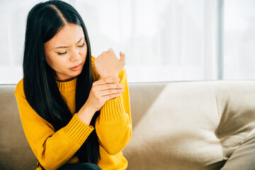 A woman holds her achy wrist indicating Carpal Tunnel Syndrome or wrist pain. Illustrating symptoms...