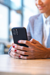 Satisfied with the results, the businesswoman who takes a break in a cafe looks at the results with satisfaction. A mature boss holds a phone in her hands, writes messages using an app.