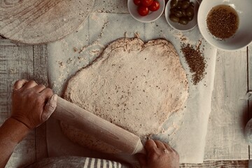 Woman preparing Italian focaccia bread simple dough of flour, oil and water.