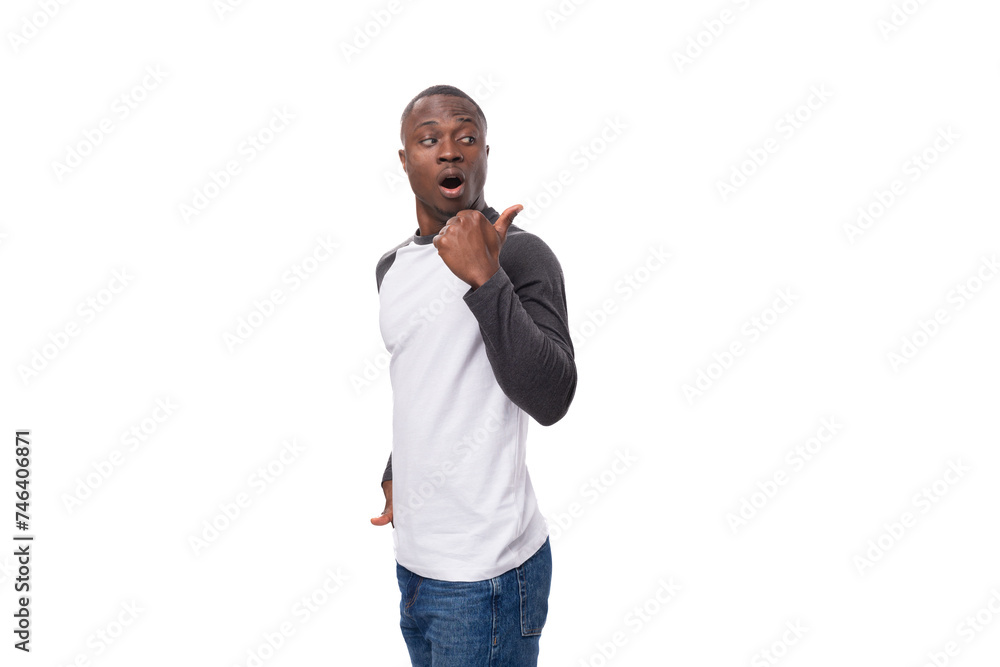 Wall mural a young smart african man with a short haircut dressed in a sweatshirt and jeans wants to communicate an idea or news