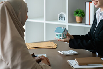 real estate agent talk about terms of home purchase agreement and ask Muslim customer to sign...