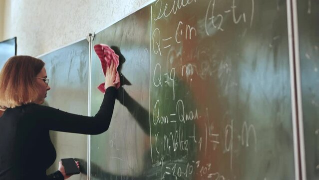 A girl washes the school blackboard after a maths lesson.