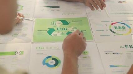 Close-up of Professionals reviewing ESG sustainability reports during a corporate strategy meeting.