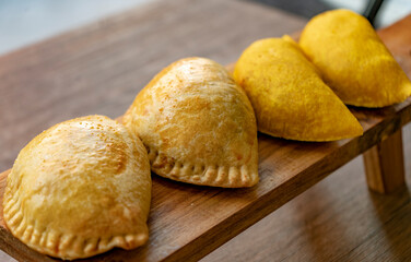 Detalle de Empanadas listas para comer en nu mostrador de madera.