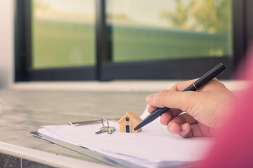 Hand Signing a home purchase contract.
