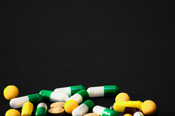 Medical pills. Color capsules medication. Black background. Health care concept. Free space for text. Medicines. Many different pills. Chemical industry.
