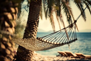 The image captures a serene beach setting with a hammock between palm trees, overlooking the ocean,...