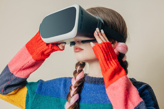 Woman wearing virtual reality simulators near wall