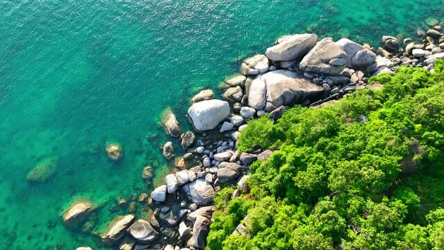 A mesmerizing drone glides over azure seas, tracing the rugged coastlines and lush foliage of a paradisiacal tropical isle. Ko Tao, Surat Thani Province, Southern Thailand. Sea background. 4K.
