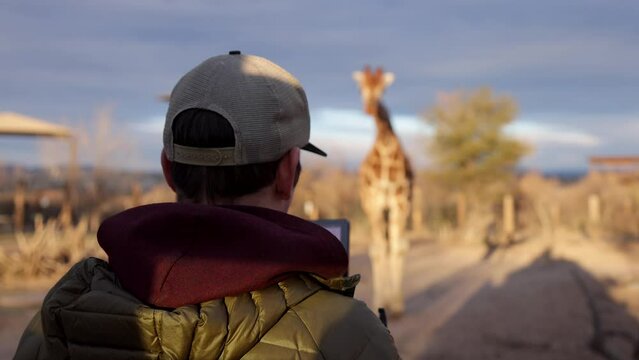 BTS wildlife cinematographer filming girafee on back of truck handheld shaky safari