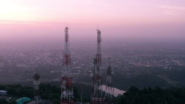 Aerial view of telecommunication towers standing on top of mountain at sunset, Arc shot 4k footage.