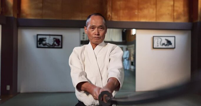 Fitness, sword or sensei martial arts in dojo for practice routine, aikido movement or self defense. Combat demonstration, mature Japanese person or training workout for fighting, education or class