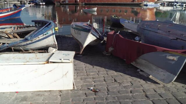 Small wooden boats in the port, filming with a steadicam, moving from left to right.