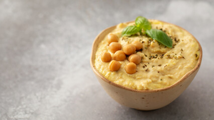 A dish of hummus made with chickpeas served with crackers on a table. Copy space