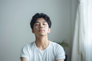 白い部屋の中で瞑想をする若い日本人男性（ストレス解消・ヨガ・精神統一） - obrazy, fototapety, plakaty