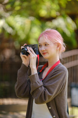 Beautiful woman with camera. Happy smiling woman taking photos of beautiful location.