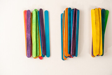 multicolored sticks scattered on a white background, background with colorful sticks, colorful sticks for creating craft 