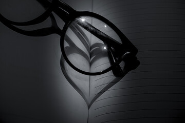 heart shape from the shadow or reflection of the glasses on the book