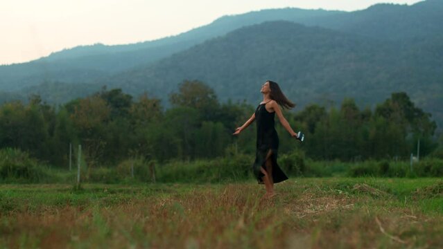 A figure of a young woman with a retro camera spinning around in nature
