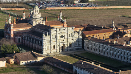 Obraz premium Drone shot over Certosa di Pavia monastery with lawn fields in Italy, Pavia