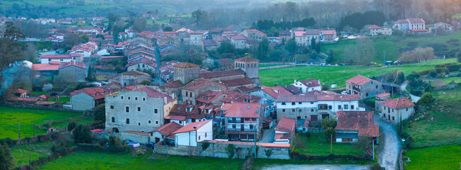 Naklejka premium Winter landscape of the town of Santillana del Mar at dusk seen from a drone. Municipality of Santillana del Mar. Community of Cantabria. Spain. Europe